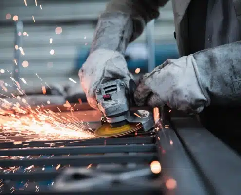 Handwerkliche Tätigkeit mit Funkenflug, Symbol für nachhaltiges Wirtschaften im produzierenden Gewerbe.